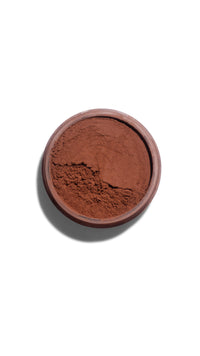 Brown powder in a round container on a white background